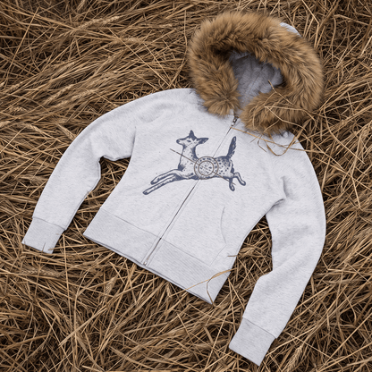 A light gray zip-up hoodie with a brown faux-fur trimmed hood, laid flat on a bed of dry straw. The front features a graphic of a jumping deer with a red crosshair pattern.