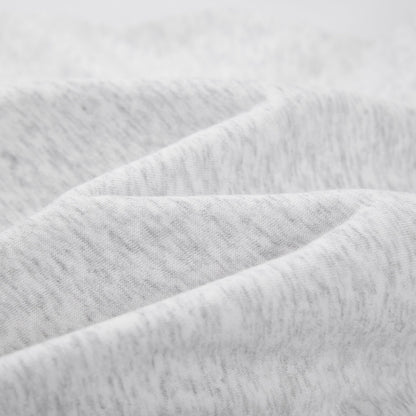 Close-up of light heather gray fabric with soft folds and a textured knit surface.