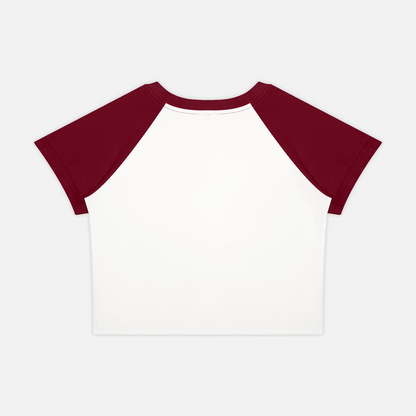A short-sleeve raglan crop top with a white body and dark burgundy sleeves, shown flat against a light gray background.