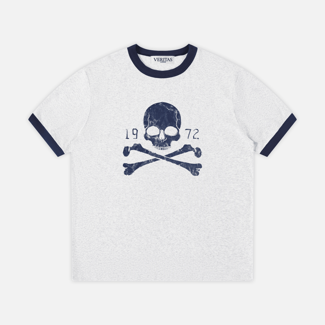 A gray heather ringer t-shirt with navy blue trim on the crew neck and sleeve cuffs, featuring a navy blue skull and crossbones graphic with '1972' text on the chest. VERITAS woven neck tag.