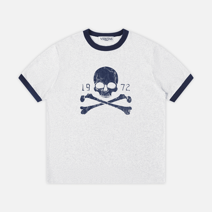 A gray heather ringer t-shirt with navy blue trim on the crew neck and sleeve cuffs, featuring a navy blue skull and crossbones graphic with '1972' text on the chest. VERITAS woven neck tag.